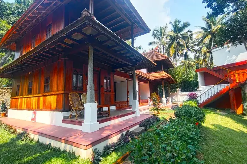 Classic wooden palace architecture and traditional villa facade at The Travancore Heritage Beach Resort