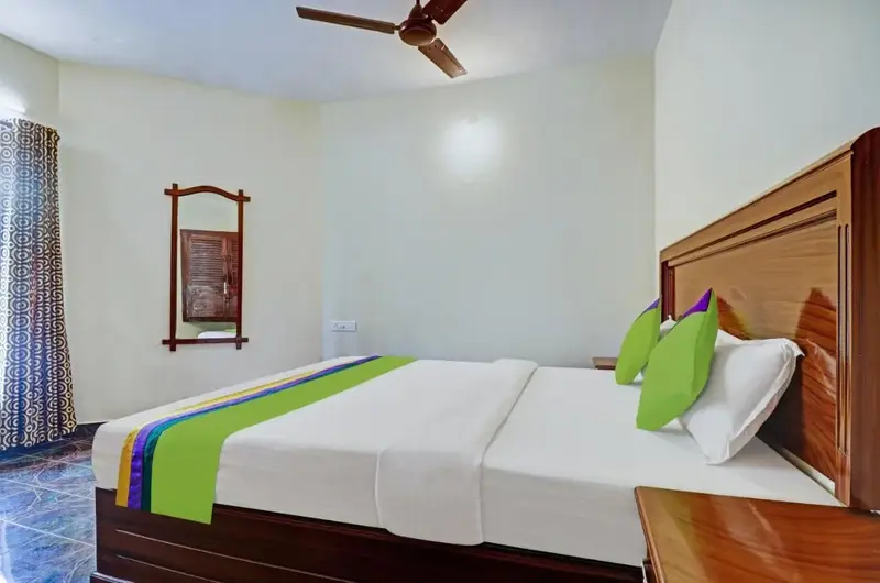 Standard guest bedroom accommodation featuring clean linens at Treebo Trend Linchu Ayur Resort Kovalam