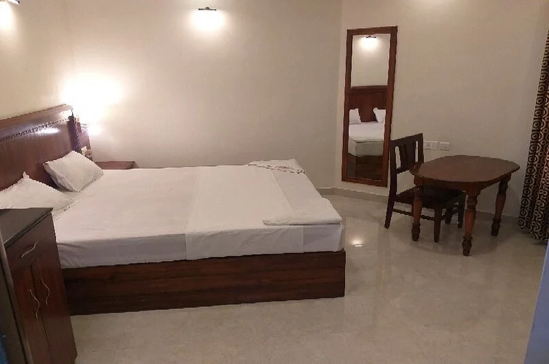 Deluxe resort bedroom layout with an attached seating space at Treebo Trend Linchu Ayur Resort