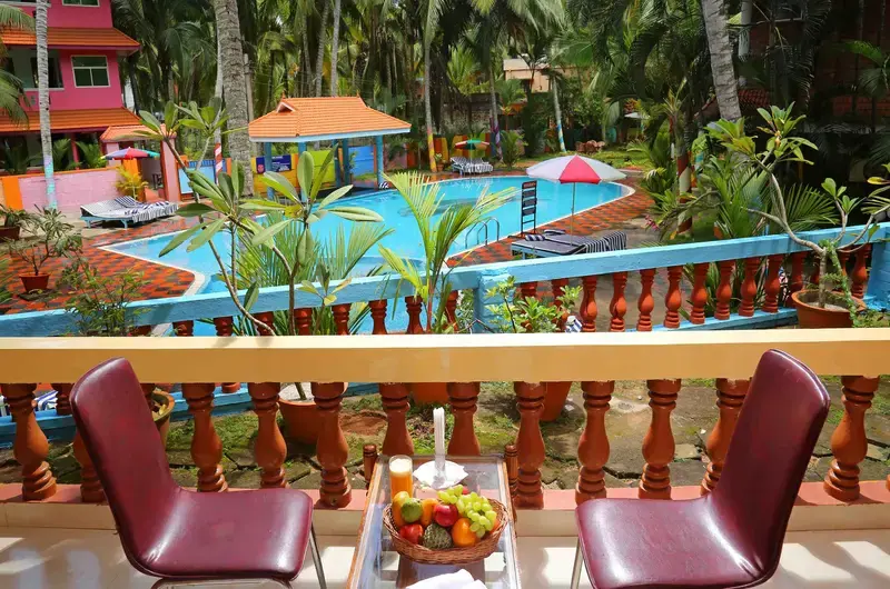 Comfortable outdoor pool deck seating arrangement with chairs at Jasmine Palace Kovalam.