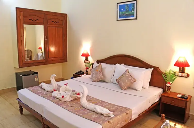 Deluxe double bedroom interior at Jasmine Palace Kovalam with comfortable furnishings.