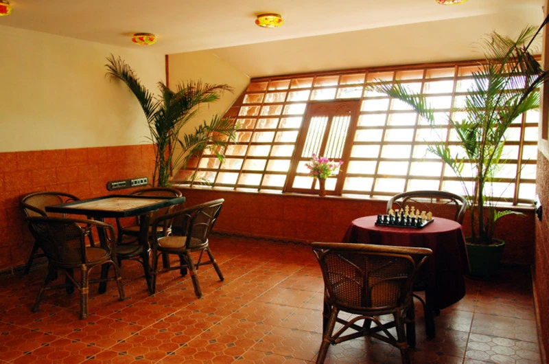 Indoor recreation area and lounge space featuring large windows at Kovalam Beach Hotel.