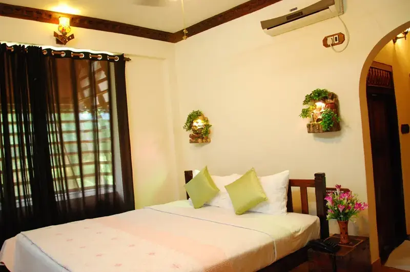 Comfortable air-conditioned double bedroom accommodation with minimalist decor at Kovalam Beach Hotel.