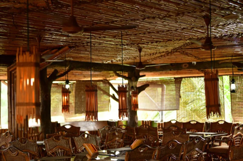 Modern indoor restaurant counter and dining tables setup at La Promenade Hotel Kovalam.