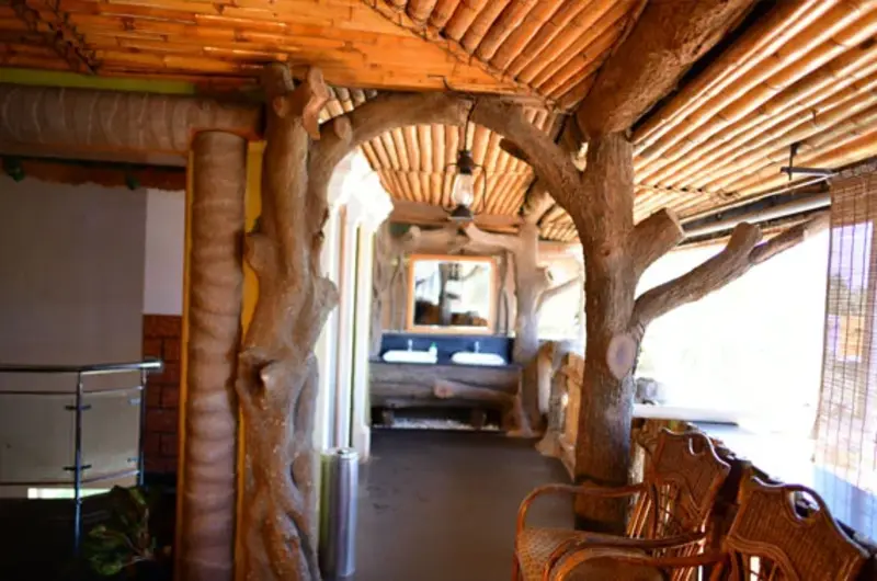 Cozy indoor wooden cafe lounge and guest walkway area at La Promenade Hotel Kovalam.