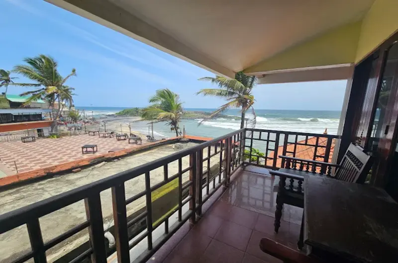 Private wooden balcony railing looking out over the beach coastline at Hotel Marine Palace Kovalam.