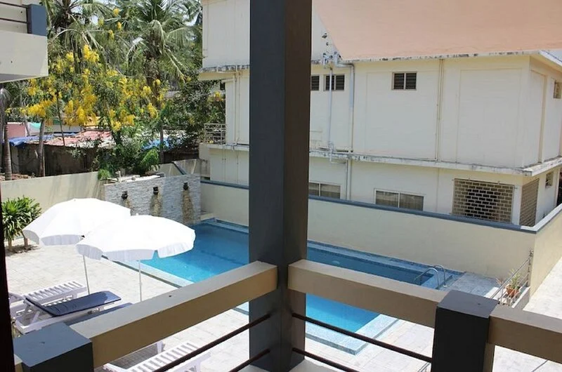 Open-air courtyard seating area featuring patio umbrellas at New Kovalam Beach Hotel.