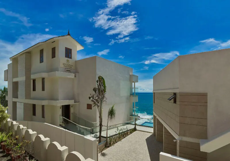 Modern white architecture and private sea view balconies at Rockholm Ayurvedic resort.