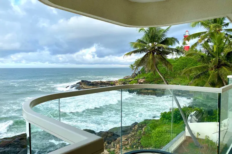 Luxury curved glass balcony offering panoramic ocean views at Rockholm Ayurvedic resort.