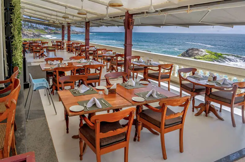 Outdoor seaside dining terrace and restaurant tables overlooking the ocean at Rockholm hotel.