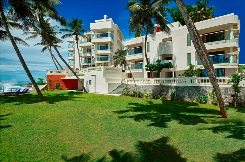 Manicured green seaside lawn and palm trees at Rockholm at the Lighthouse Beach Kovalam.
