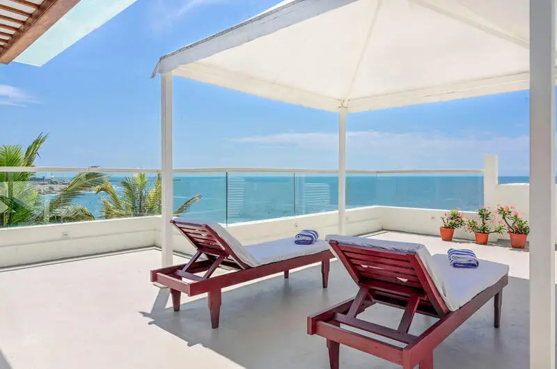 Rooftop relaxation deck with comfortable sun loungers at Rockholm Ayurveda hospital.