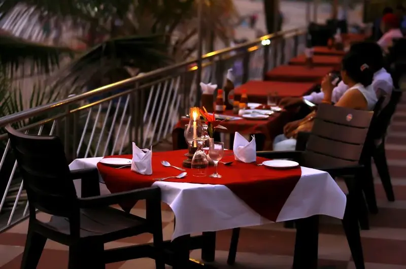 Romantic beachfront evening dining table setup with candles at Hotel Sea Face Kovalam.