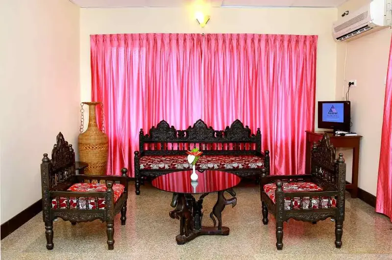 Elegant guest living room lounge featuring traditional wooden furniture at Hotel Sea Face Kovalam.