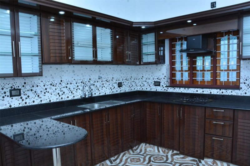 Clean shared guest kitchen counter and spacious dining area layout at Bougainvillea Homestay Kovalam.