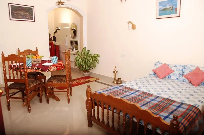 Spacious family bedroom arrangement with multiple beds and colorful floral linens at Devikripa Homestay Kovalam.