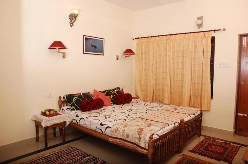 Comfortable double bedroom accommodation with warm wooden panel wardrobes at Devikripa Homestay Kovalam.