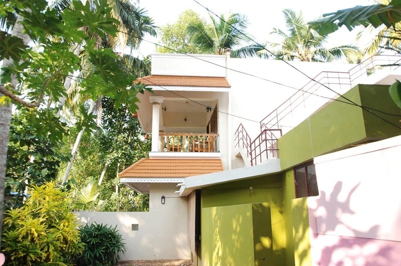 Tiled gabled entrance porch and beautiful green garden setting at Devikripa Homestay Kovalam.
