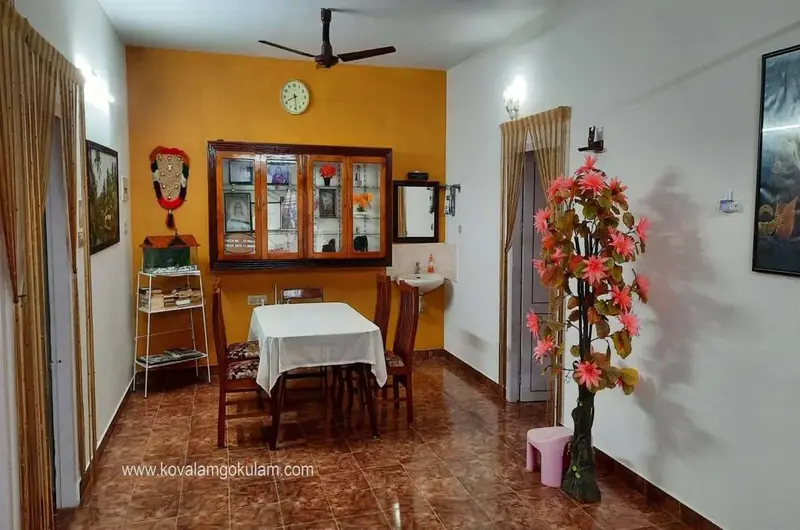 Clean indoor family dining room area with wooden tables at Gokulam Homestay Kovalam.
