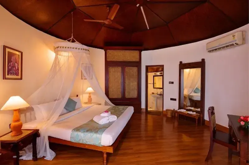 Traditional heritage bedroom accommodation with a mosquito net setup at Soma Manaltheeram Ayurvedic Hospital & Research Centre Kovalam