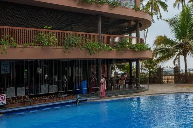 Luxury poolside relaxation deck and coconut groves at Uday Samudra Leisure Beach Hotel Kerala.