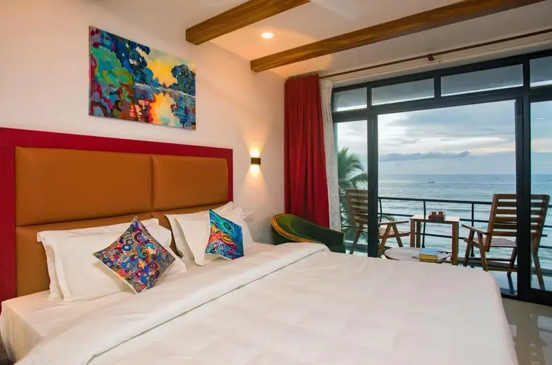 Premium sea view bedroom accommodation with wide glass windows at The Neelakanta Beach Resort Kovalam.