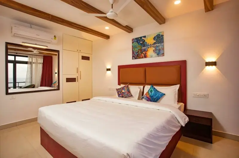 Deluxe guest room layout showcasing elegant ambient ceiling design at The Neelakanta Beach Resort Kovalam.