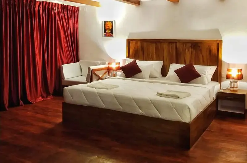 Luxury suite room interior featuring warm wooden paneling and plush red pillows at The Neelakanta Beach Resort.