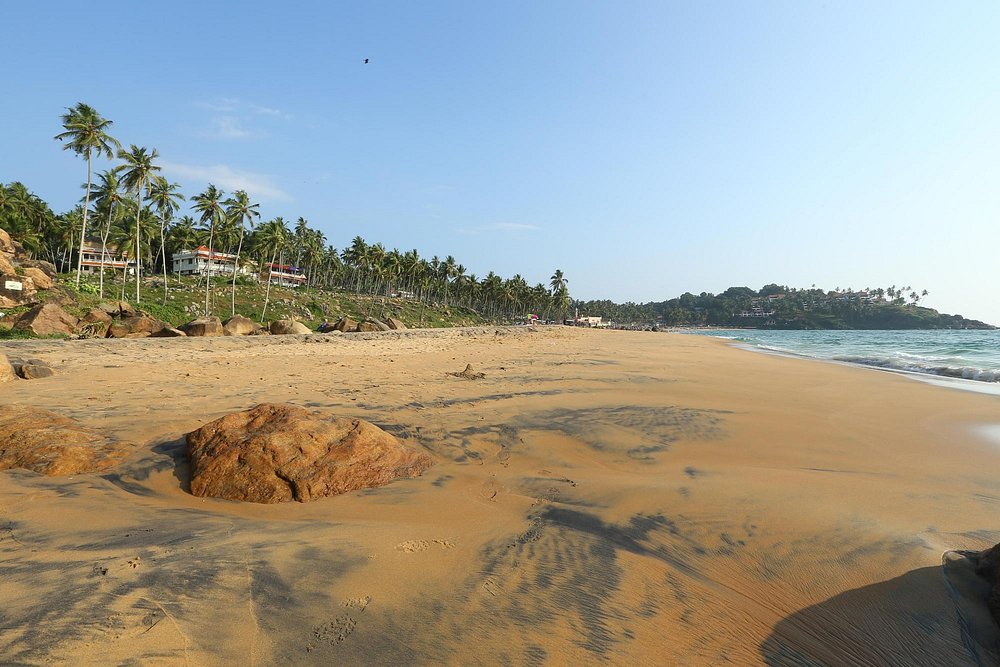 Scenic view of rolling ocean waves on the golden shores of Kovalam Beach Kerala.
