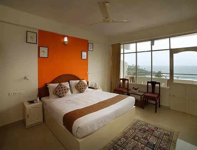 Premium sea-view room at Samudratheeram Beach Resort Kovalam featuring large windows facing the ocean.