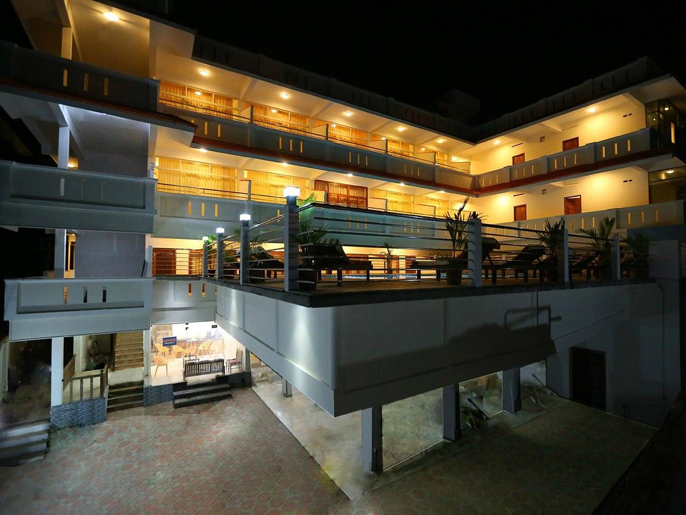 Multi-story building of Samudratheeram Beach Resort Kovalam illuminated with warm lights at night.