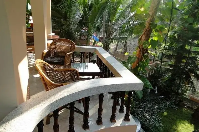 Private arched balcony sit-out area with elegant white railings at Maharaju Palace Kovalam.