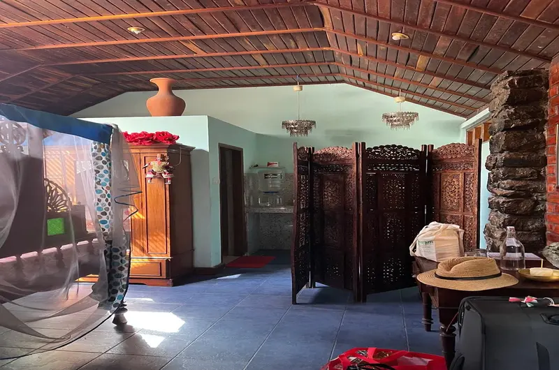 Premium guest bedroom suite showcasing polished wooden ceiling panels and partition screen at Maharaju Palace Kovalam.