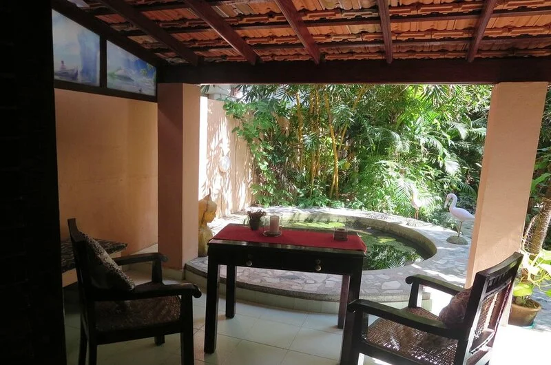 Semi-open thatched roof dining lounge and garden sitting area at Maharaju Palace Kovalam.