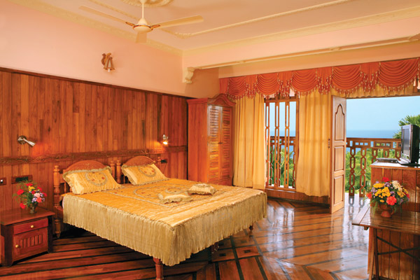 Comfortable AC guest room with warm ambient lighting at Sun Tara Beach Resort Kovalam