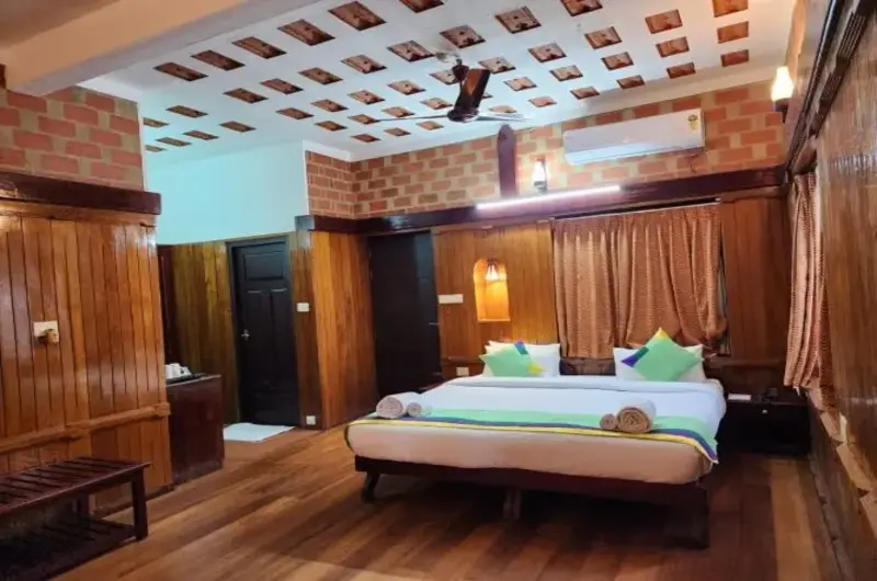 Premium heritage suite bedroom with a wooden ceiling at Gods Own Country Ayurveda Resort Kovalam