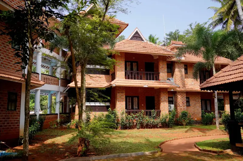 Red brick resort accommodation building at Gods Own Country Ayurveda Resort