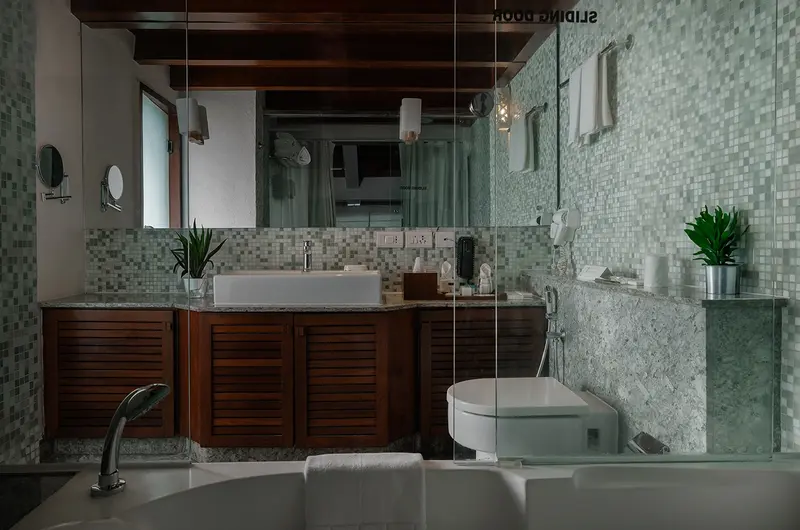 Luxury ensuite bathroom with double vanity mirrors at Gokulam Grand Turtle on the Beach Kovalam