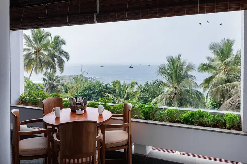Private balcony dining setup overlooking the Arabian Sea at Gokulam Grand Turtle on the Beach