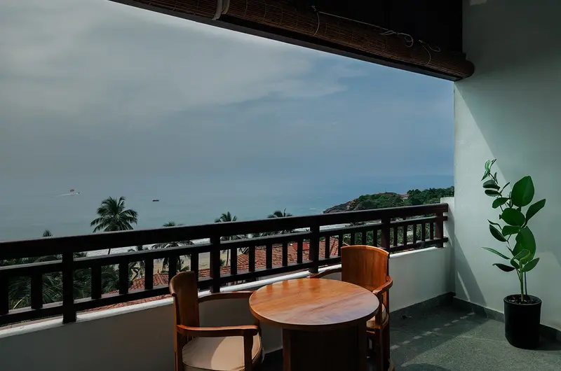 Private resort balcony with outdoor seating and scenic ocean views at Gokulam Grand Turtle on the Beach
