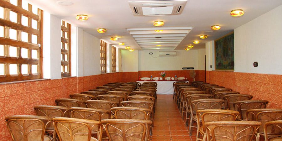 Spacious indoor conference hall and group assembly room with neat seating rows at Kovalam Beach Hotel.