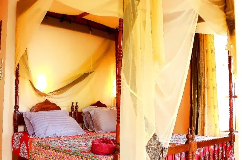 Cozy budget twin bedroom layout with warm ambient lighting and cream linens at Maharaju Palace Kovalam.