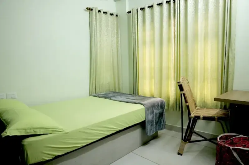Comfortable double bedroom rental with neat bedding and curtains at The Nest Homestay Kovalam.