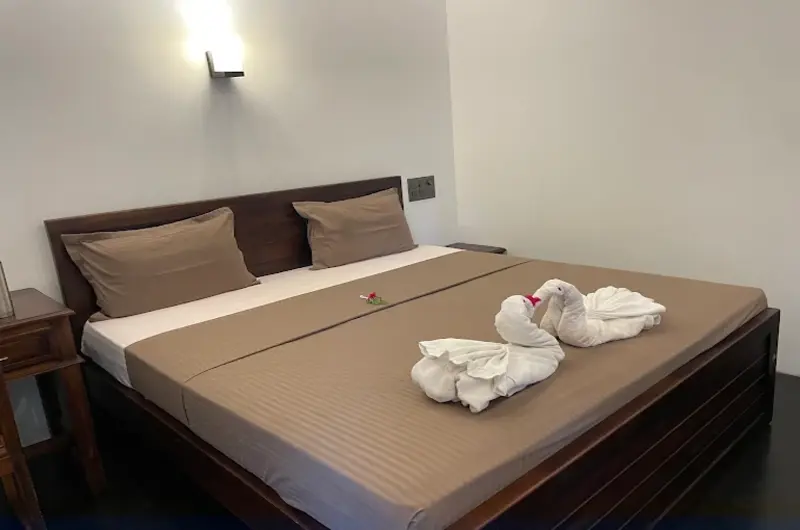Deluxe double bedroom accommodation featuring minimalist design and neat linens at Jeevan Homestay Kovalam.