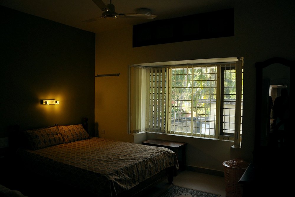 Comfortable budget double bedroom accommodation with large glass windows at Little Paradise Homestay Kovalam.