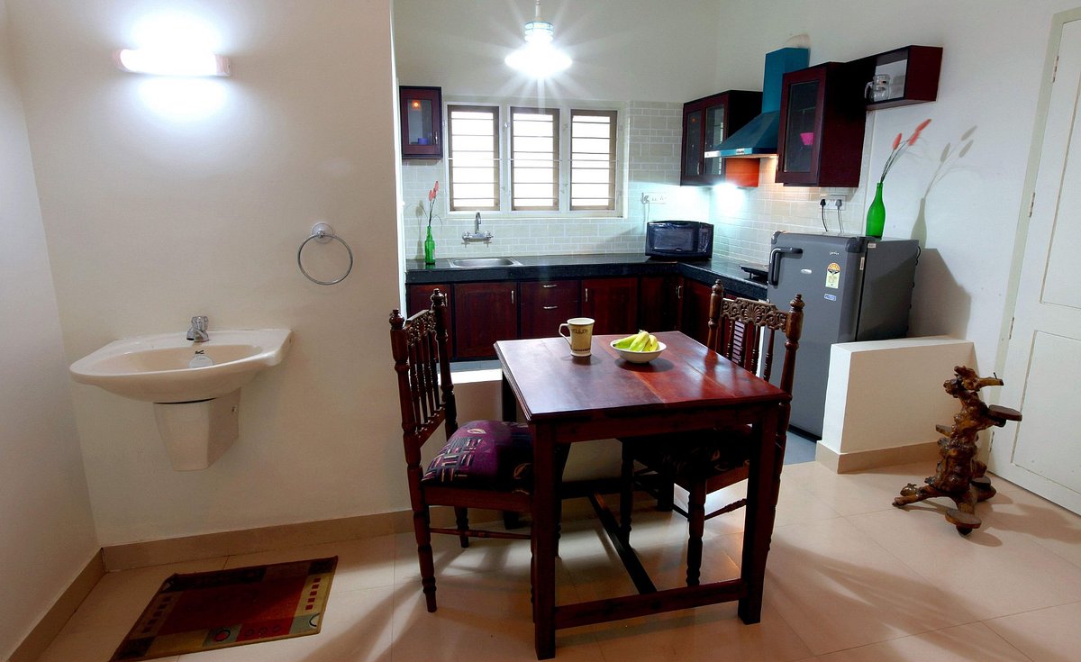 Shared family dining room table setup with an attached washbasin counter at Little Paradise Homestay Kovalam.
