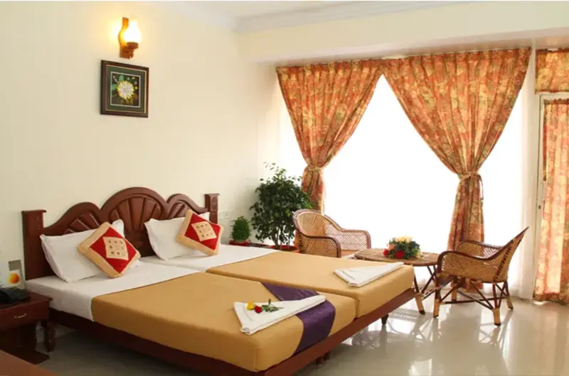 Well lit hotel room interior with classic seating area at Rock N Beach Kovalam