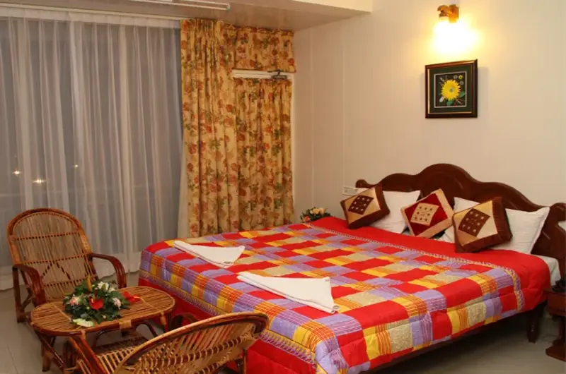 Spacious guest room setup with vibrant bed linens at Rock N Beach Kovalam