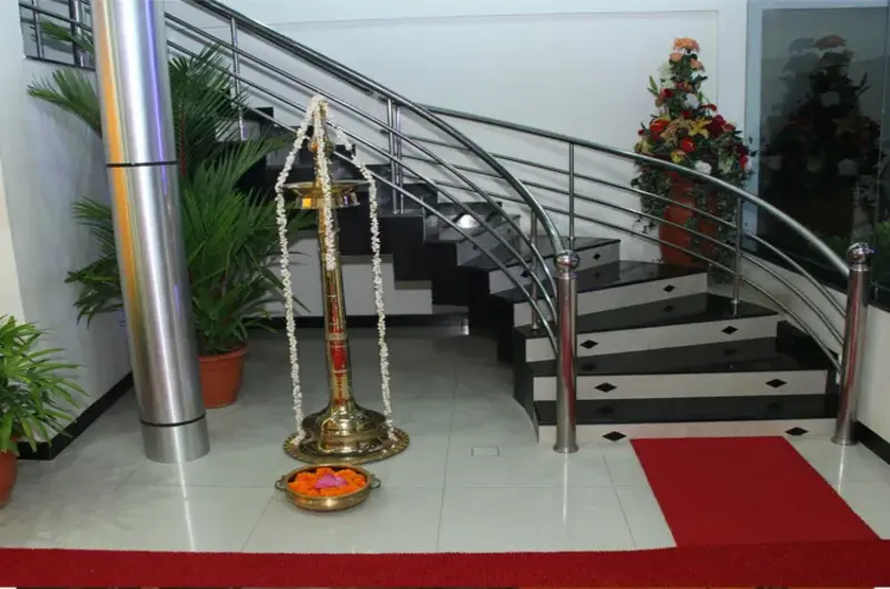 Hotel reception lobby and decorated spiral staircase at Rock N Beach Kovalam