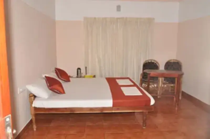 Spacious guest bedroom with double bed and classic curtains at Vayalkara Seaside Resort Kovalam